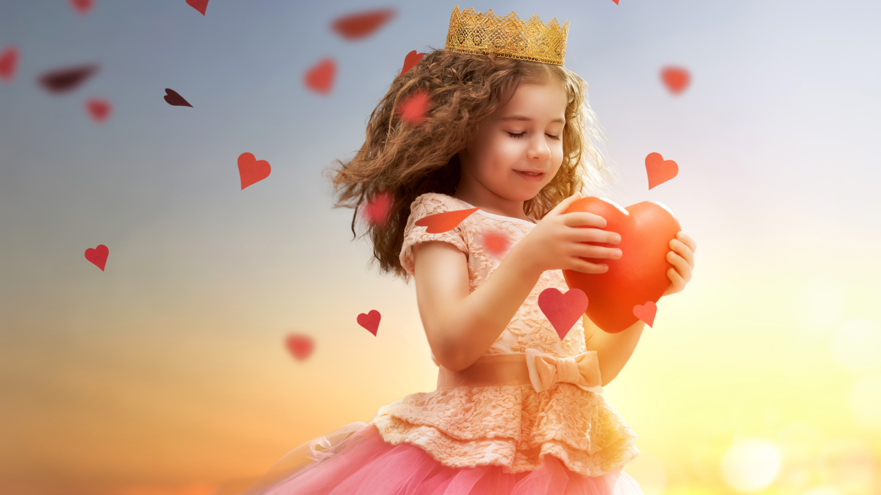 Маленькая девочка в костюме принцессы с красным сердцем в руках