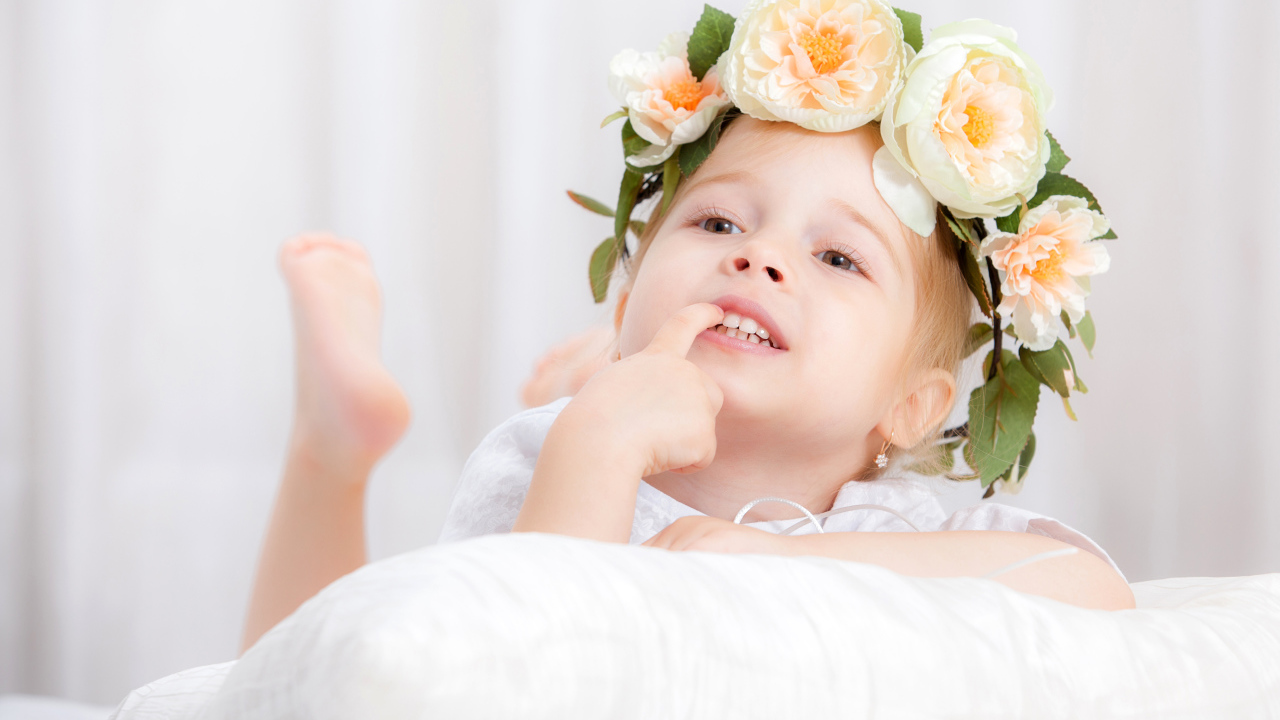 Маленькая девочка с красивым венком из цветов на голове