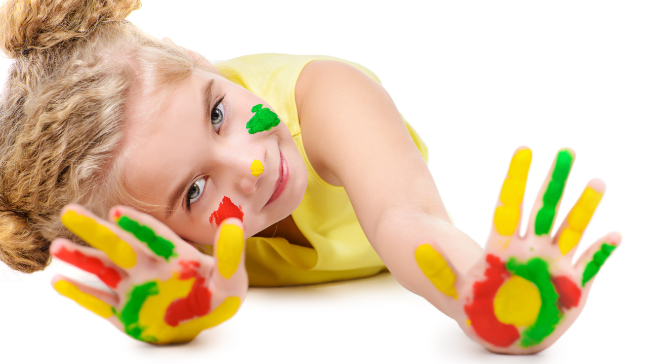 Маленькая девочка с руками в краске на белом фоне