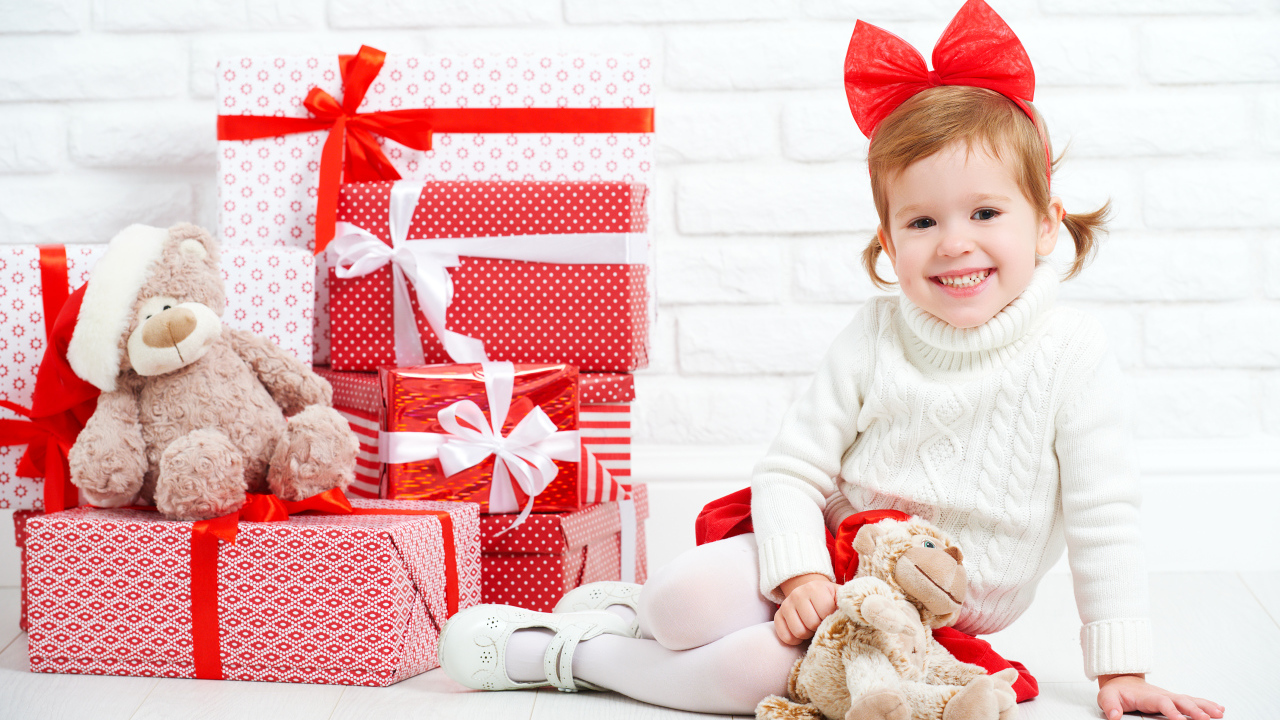 Маленькая улыбающаяся девочка с подарками на новый год