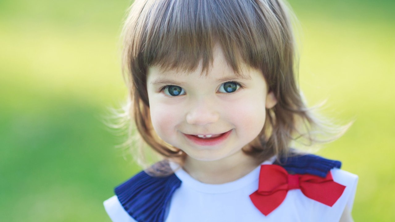 Милая улыбающаяся зеленоглазая маленькая девочка