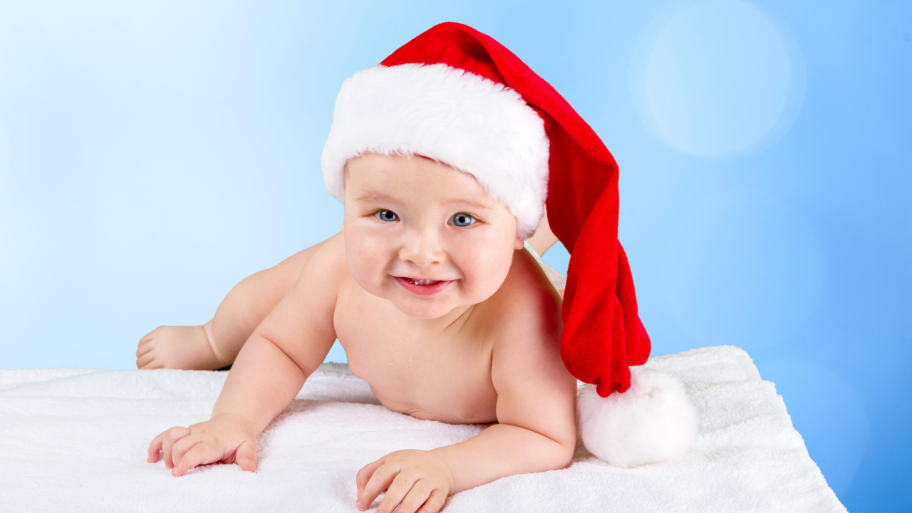 Улыбающийся грудной ребенок в новогодней шапке