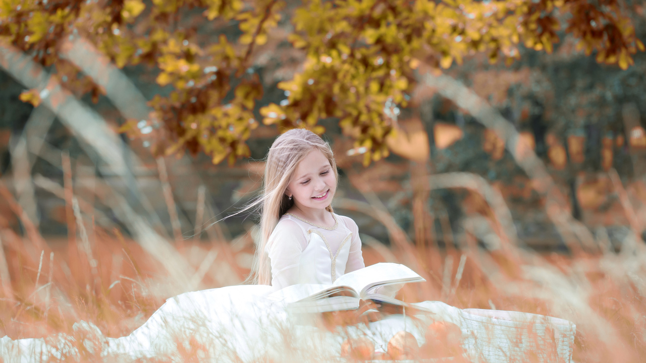 Улыбающаяся девочка в белом платье читает книгу