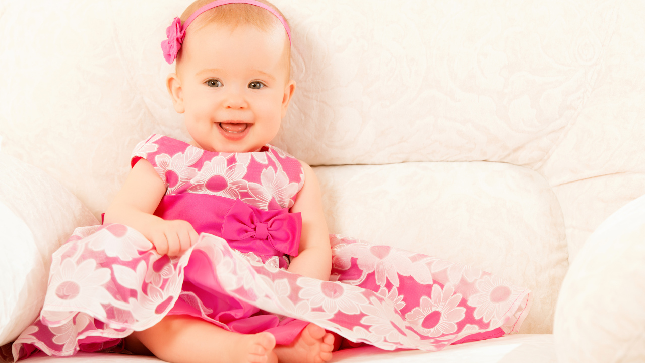 Улыбающаяся маленькая девочка в красивом розовом платье