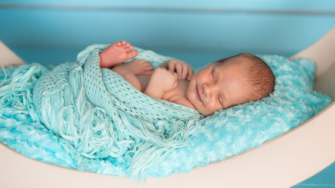 Грудной ребенок улыбается во сне