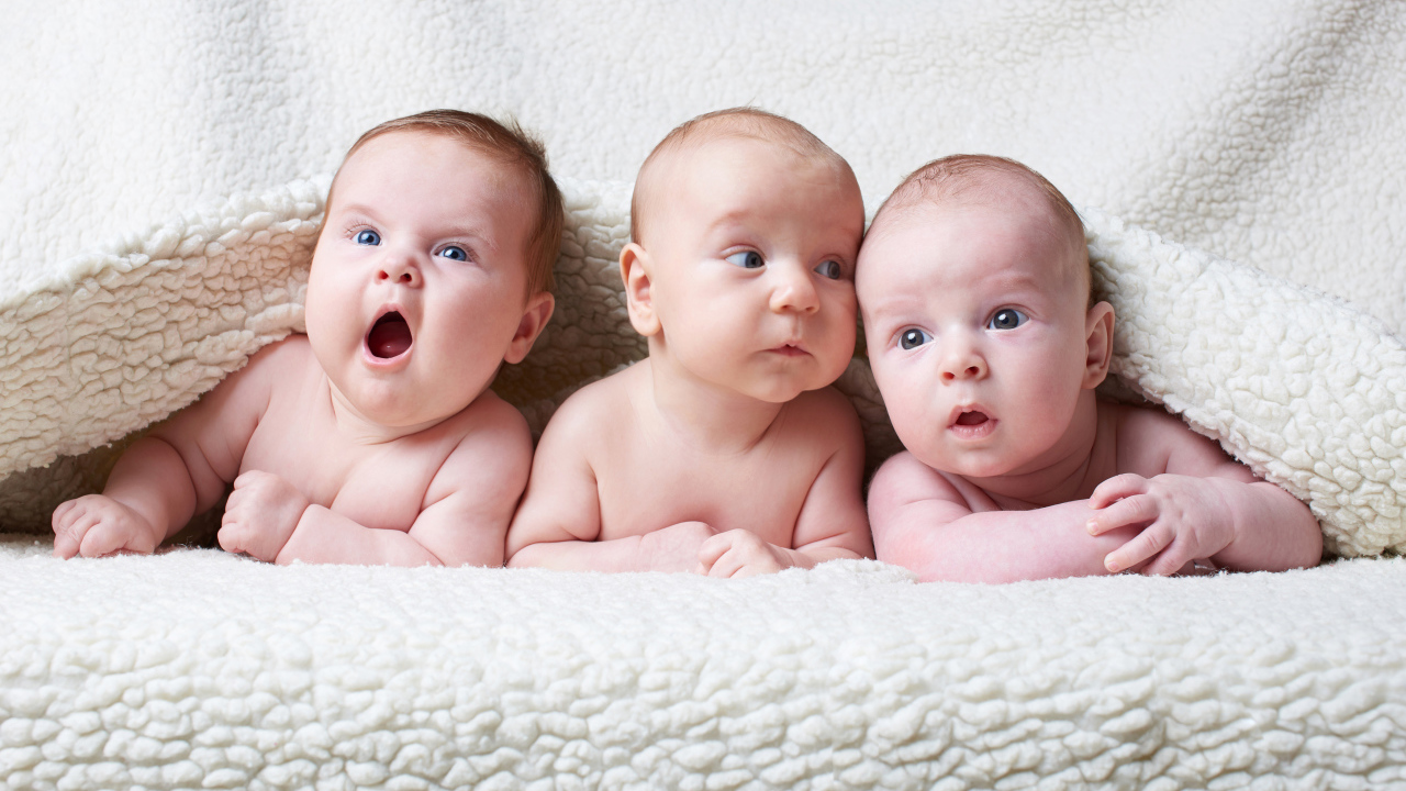 Три младенца под белым теплым одеялом