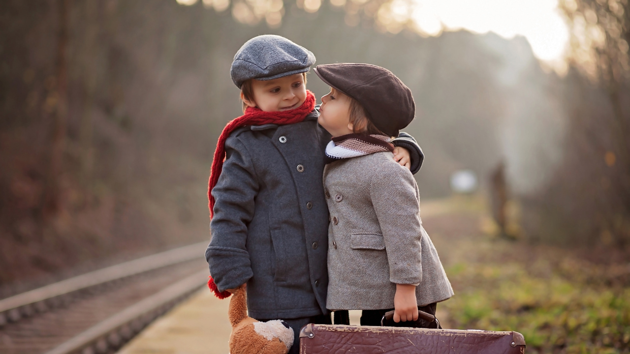 Два мальчика с большим чемоданом у железной дороги