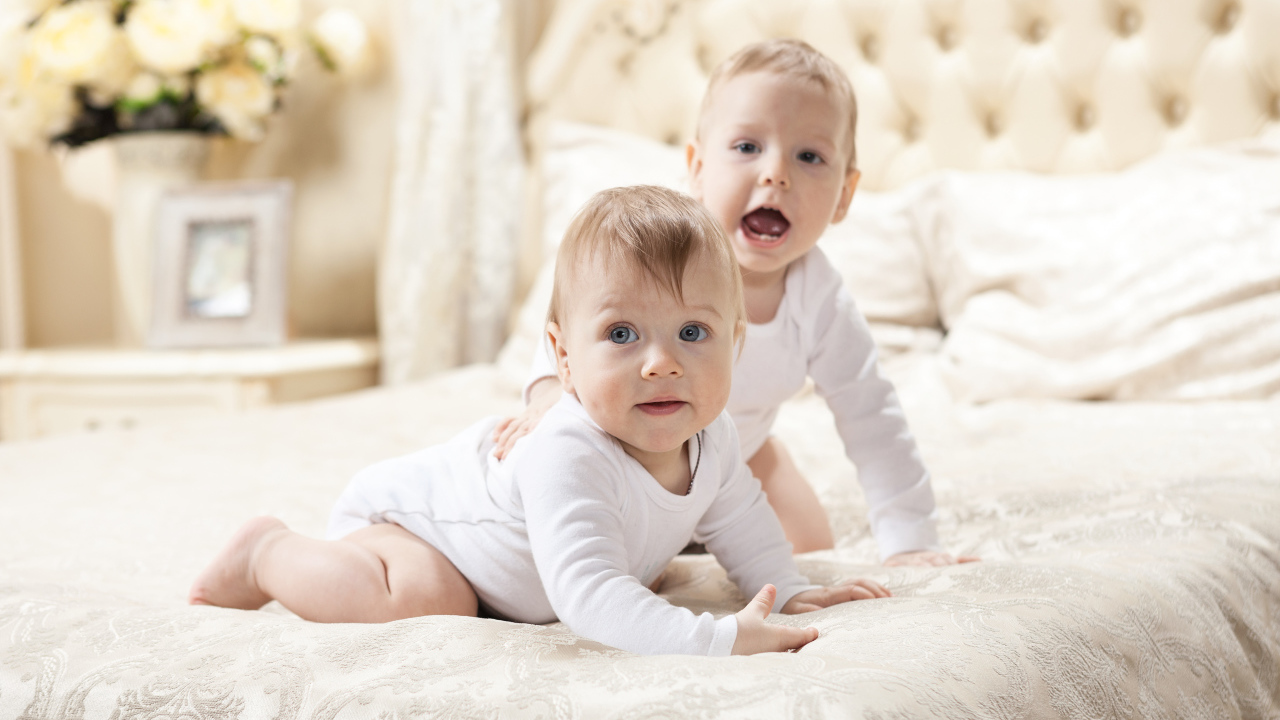 Два забавных младенца лежат на кровати