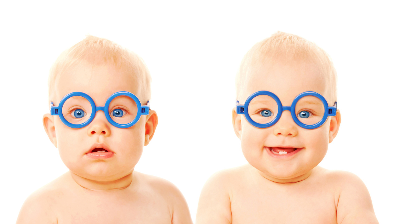 Two funny babies with blue glasses on a white background