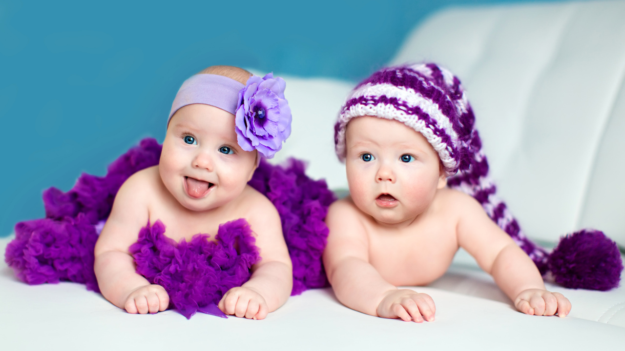 Два маленьких забавных младенца в красивых фиолетовых костюмах