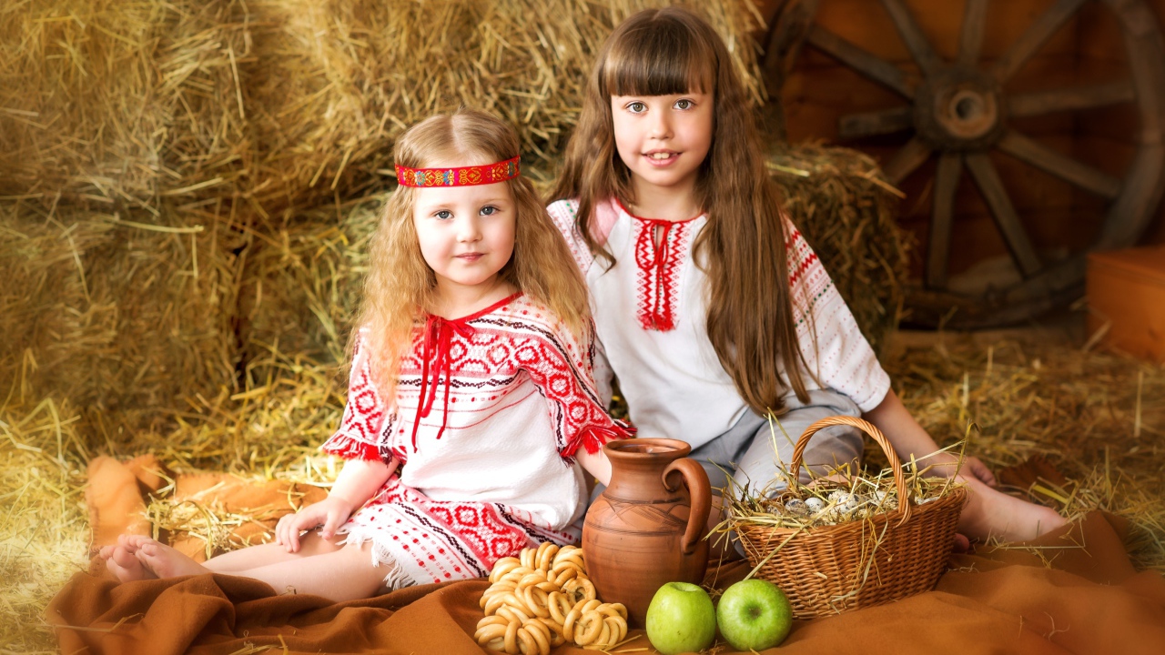 Две маленькие девочки в красивых костюмах с угощениями