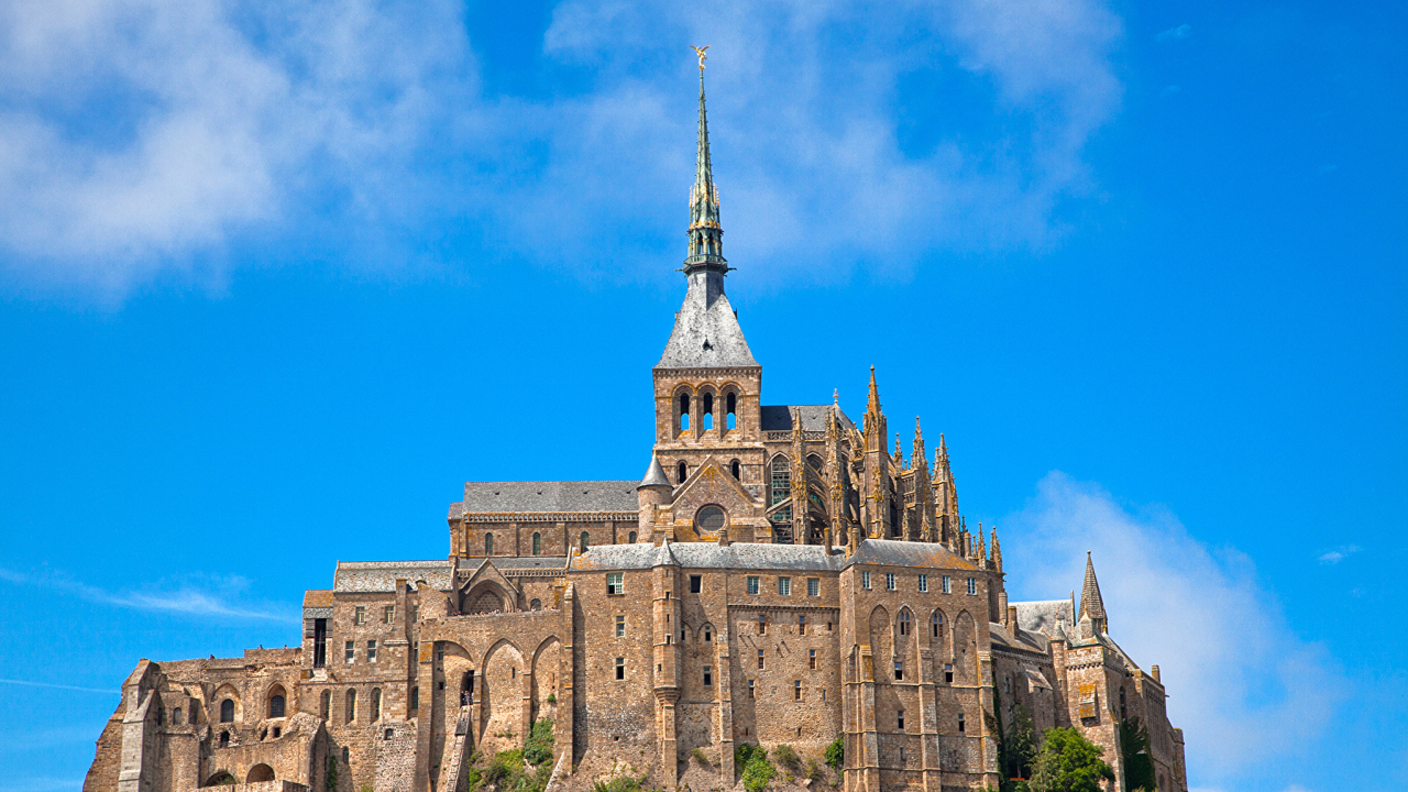 Остров крепость Мон-Сен-Мишель на фоне голубого неба, Франция