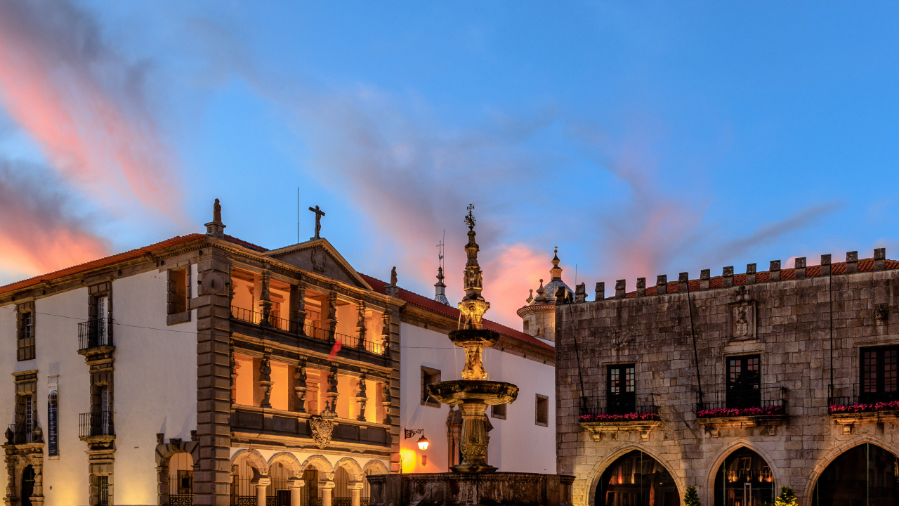 Дома и фонтан на вечерней площади в городе Вьяна, Португалия