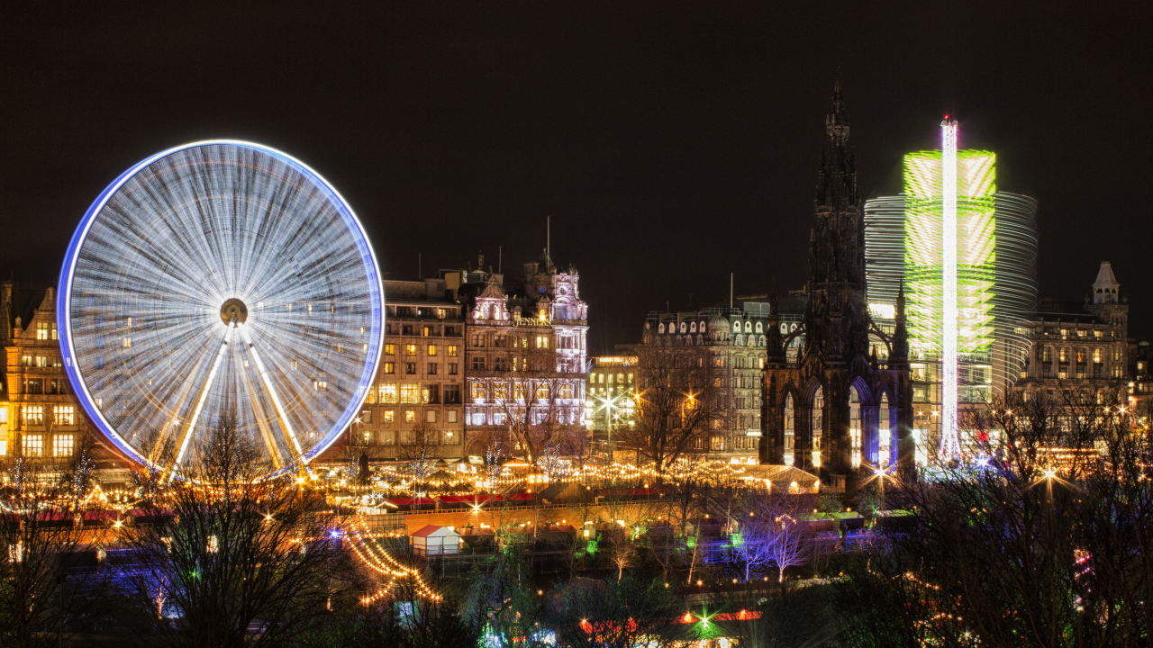 Колесо обозрения вечером на фоне города Эдинбург, Шотландия