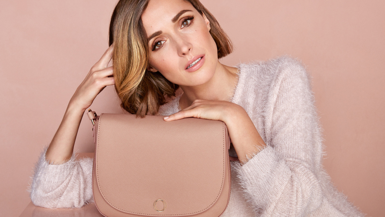 Красивая актриса Роуз Бирн в розовом свитере с сумочкой