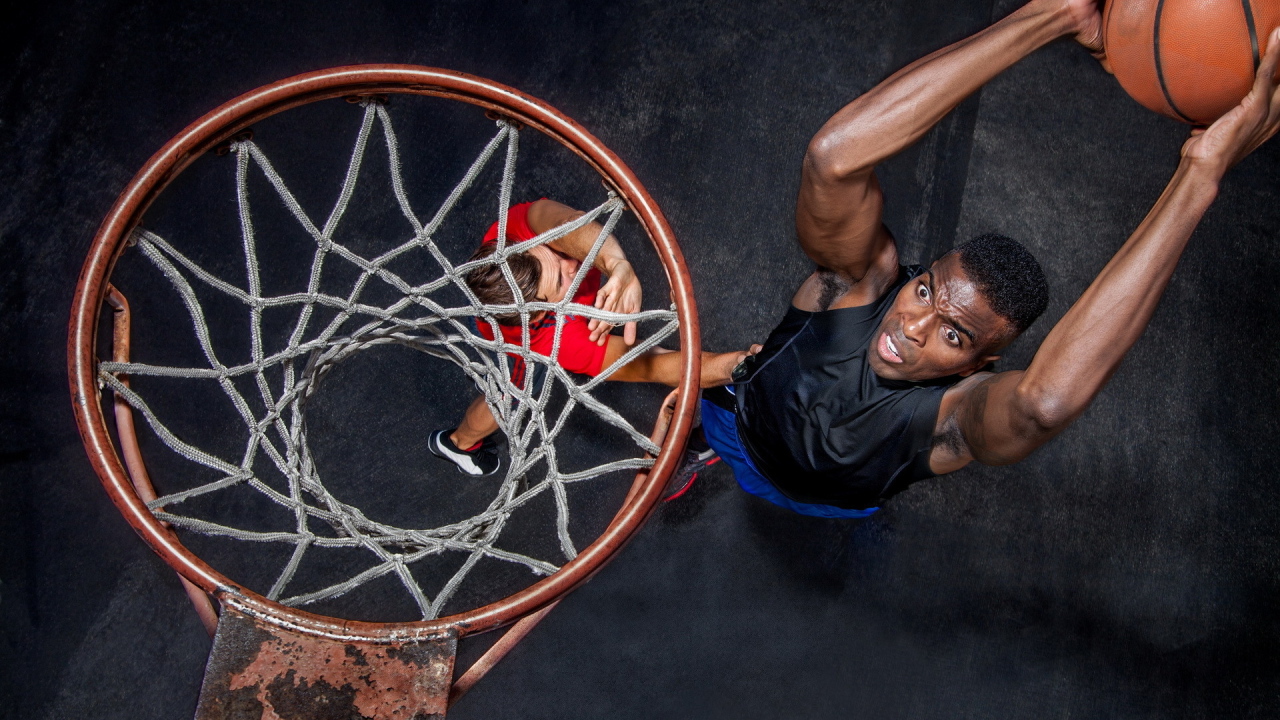 Баскетболист забрасывает мяч в кольцо 