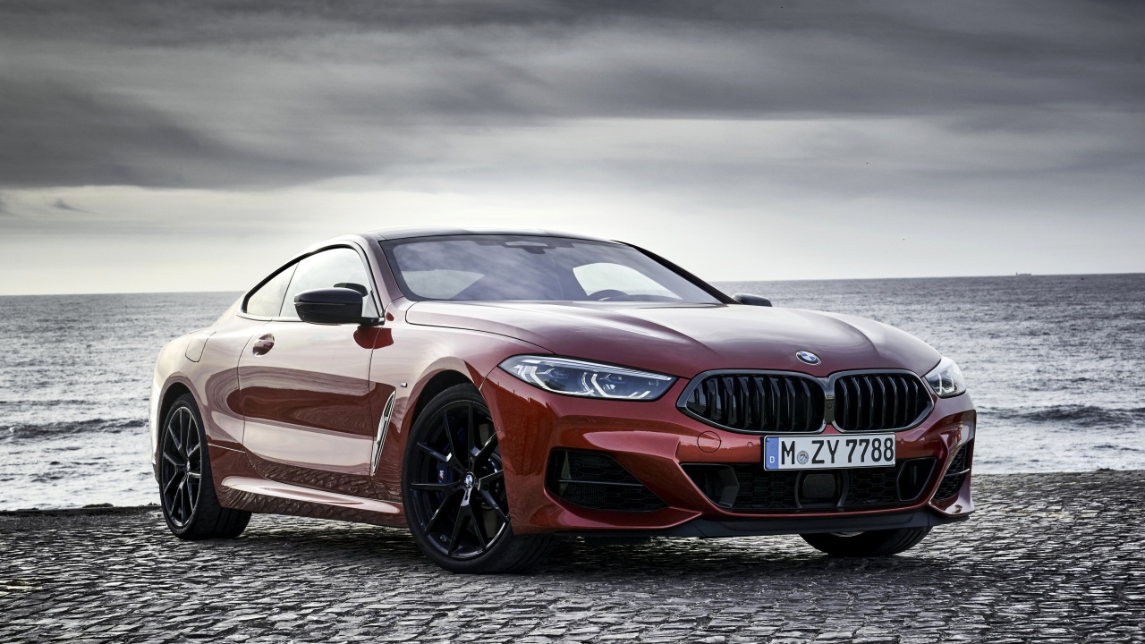 Red BMW 8 Series car on the background of the sea