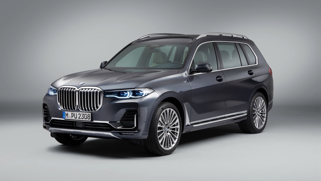 Серебристый внедорожник BMW X7, 2018 года на сером фоне