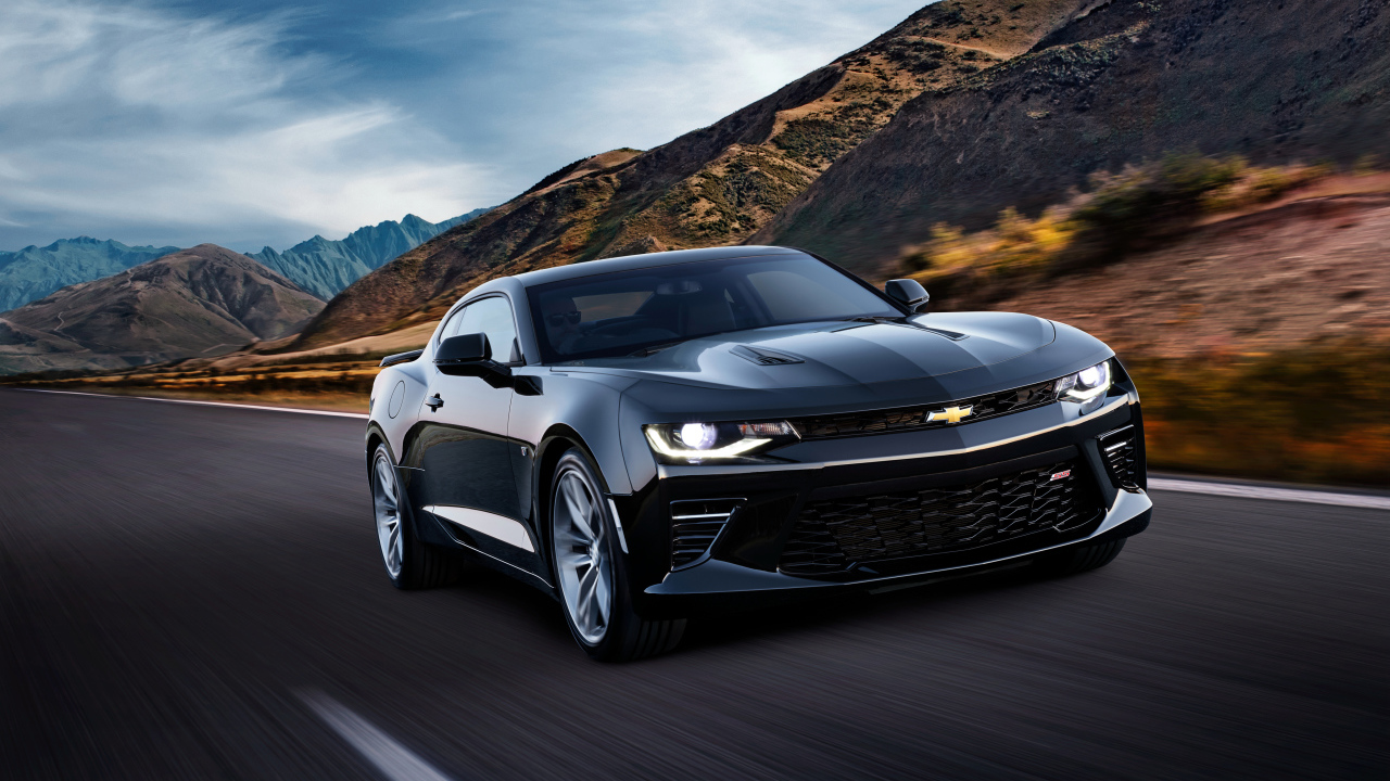 Черный быстрый автомобиль Chevrolet Camaro SS, 2018 года на трассе у гор