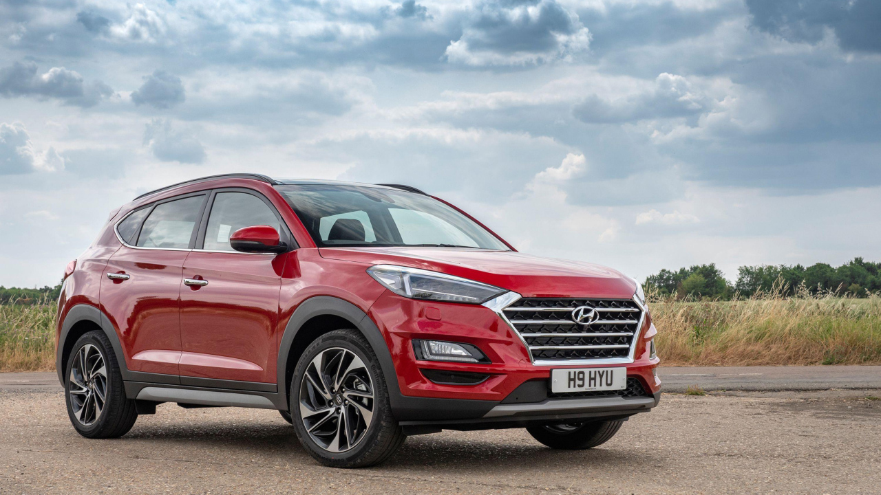 Красный автомобиль Hyundai Tucson, 2019 года под пасмурным небом