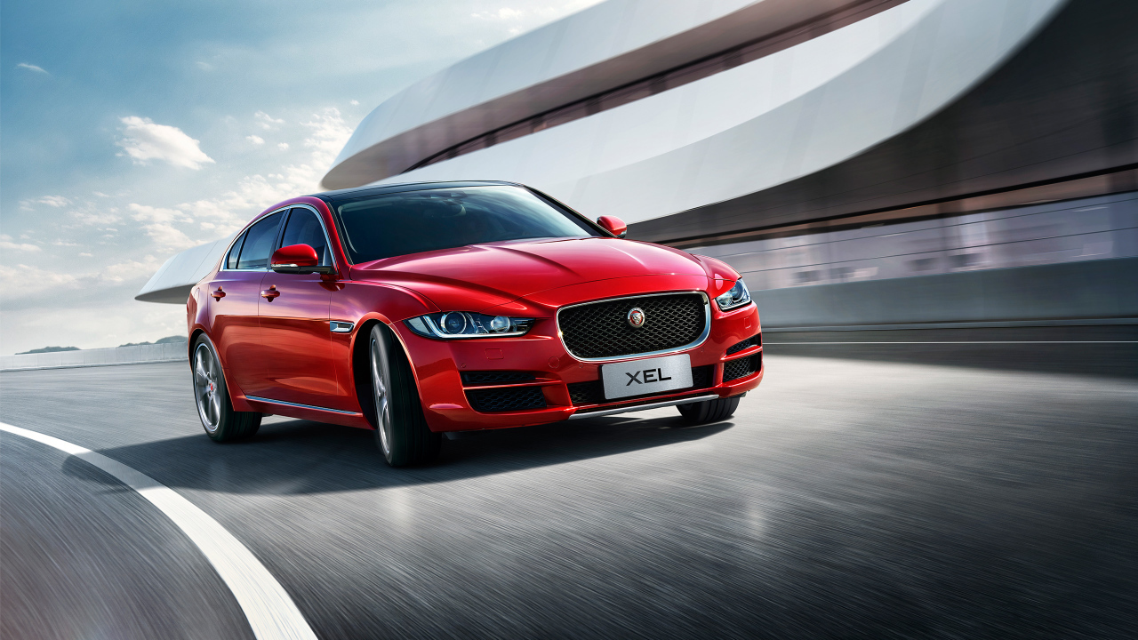 Красный автомобиль Jaguar XEL, 2018 на трассе
