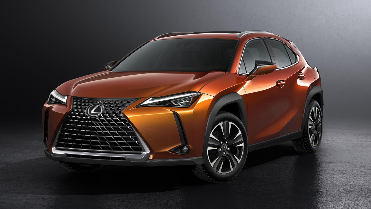 Оранжевый автомобиль Lexus UX, 2019 на сером фоне