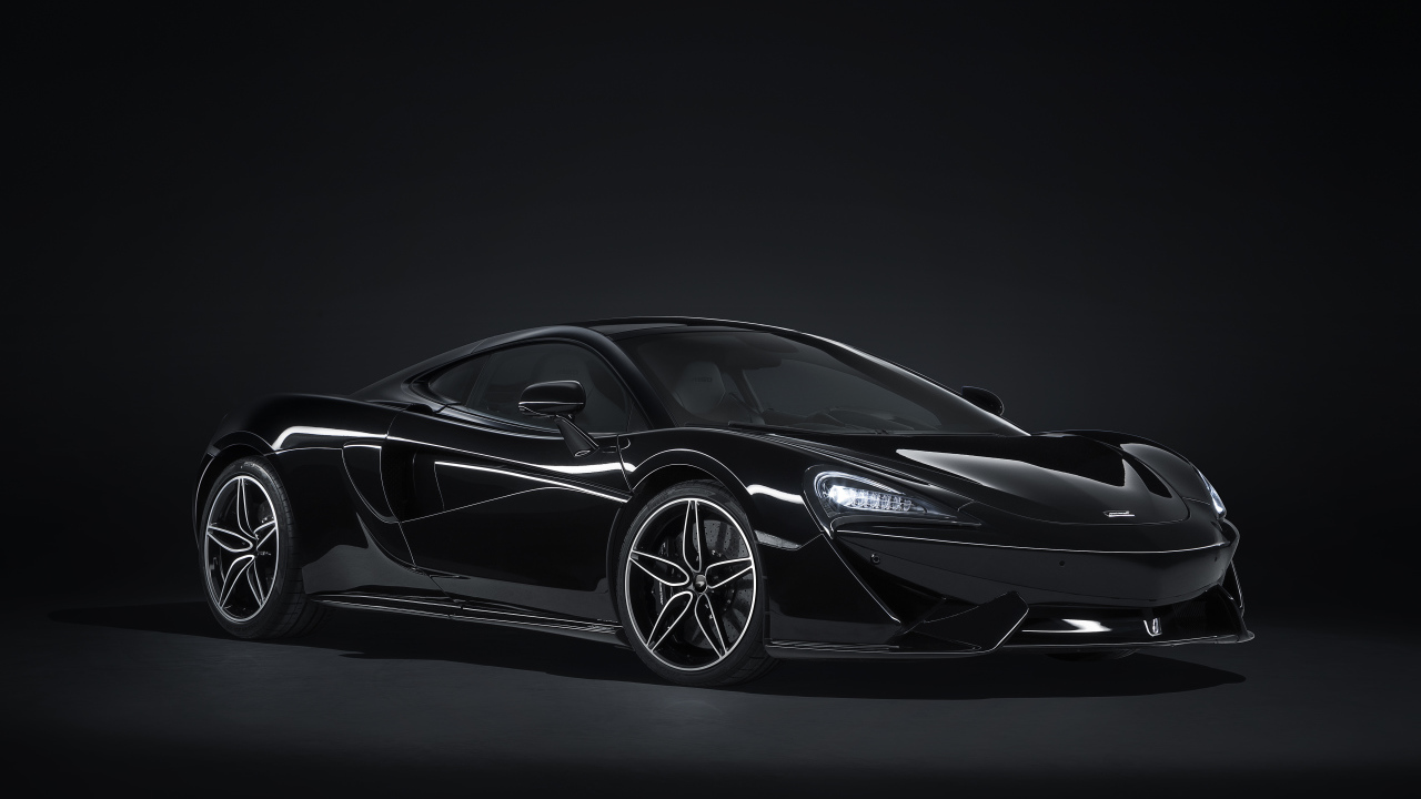 Черный автомобиль McLaren 570GT на сером фоне