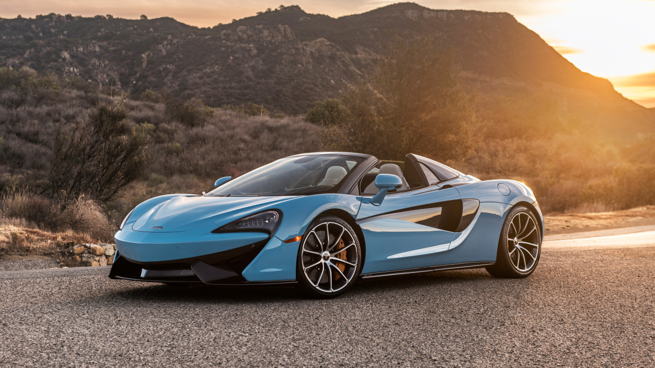 Blue sports car McLaren 570S Spider, 2018 on the background of the sun