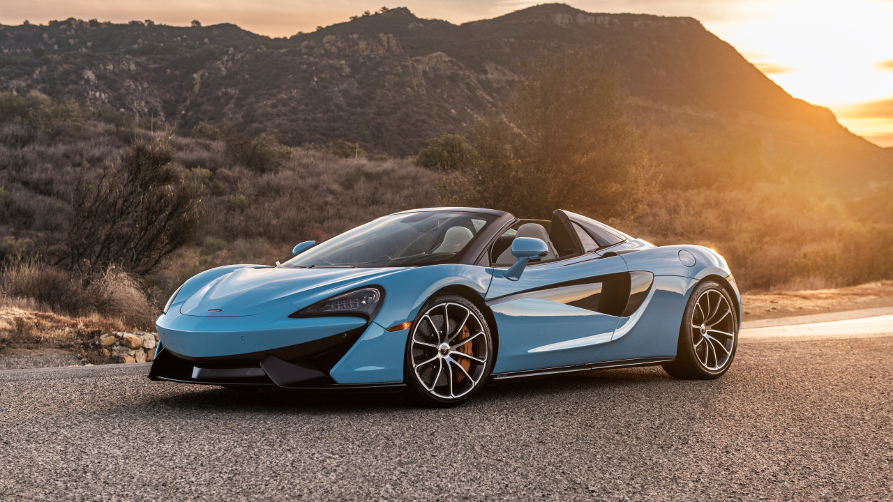 Голубой спортивный автомобиль  McLaren 570S Spider, 2018 на фоне солнца