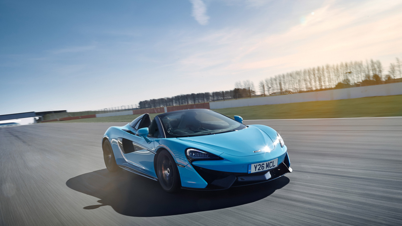 Голубой спортивный автомобиль McLaren 570S, 2018 года на трассе