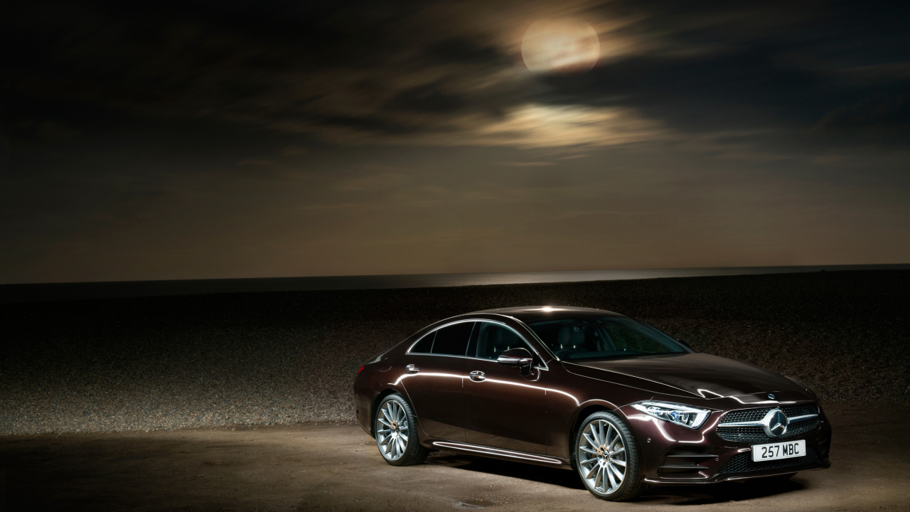 Коричневый автомобиль Mercedes Benz CLS 400 D AMG 2018 года на фоне луны