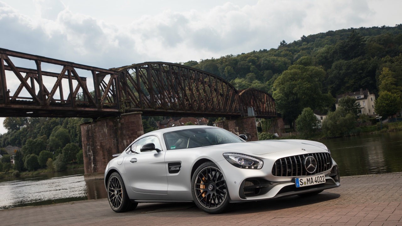 Серебристый автомобиль Mercedes-AMG GT на фоне моста