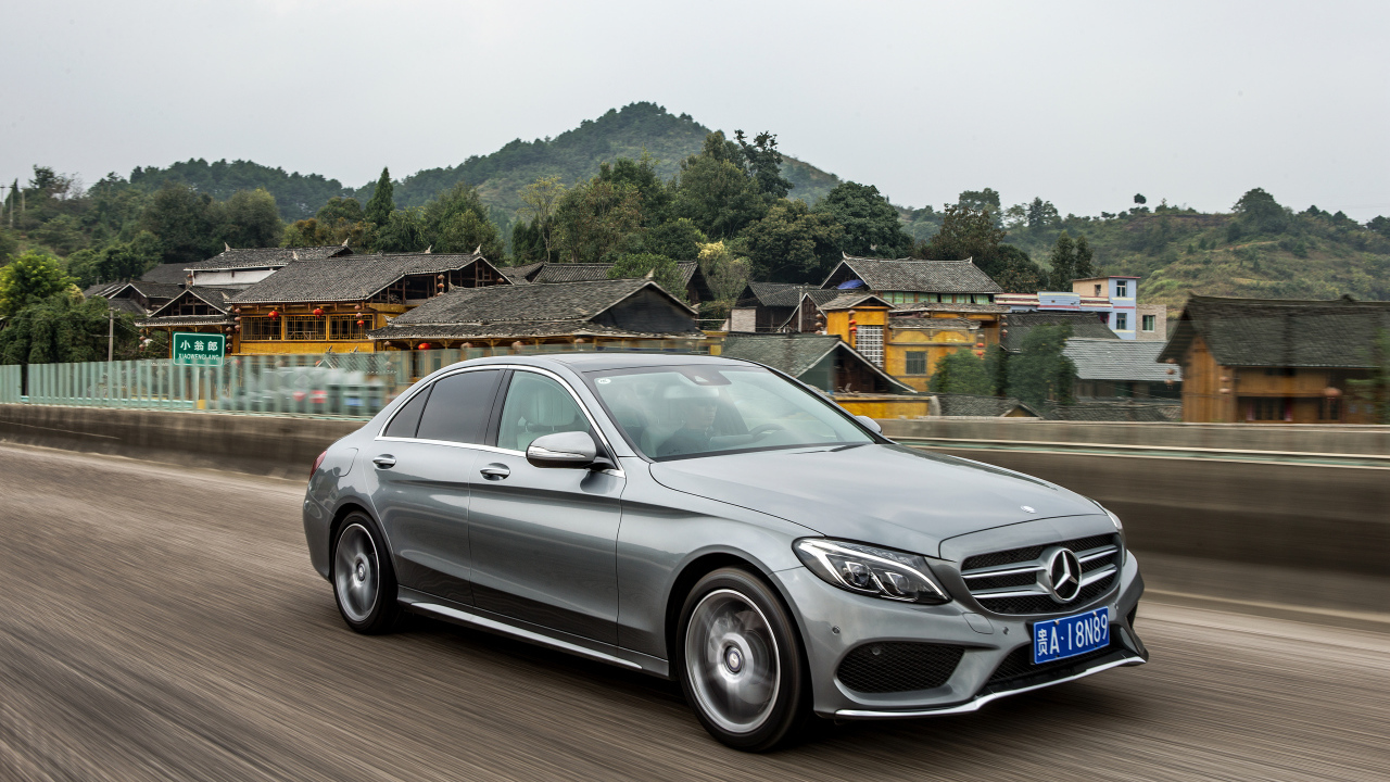 Серебристый автомобиль Mercedes-Benz C-Class на трассе