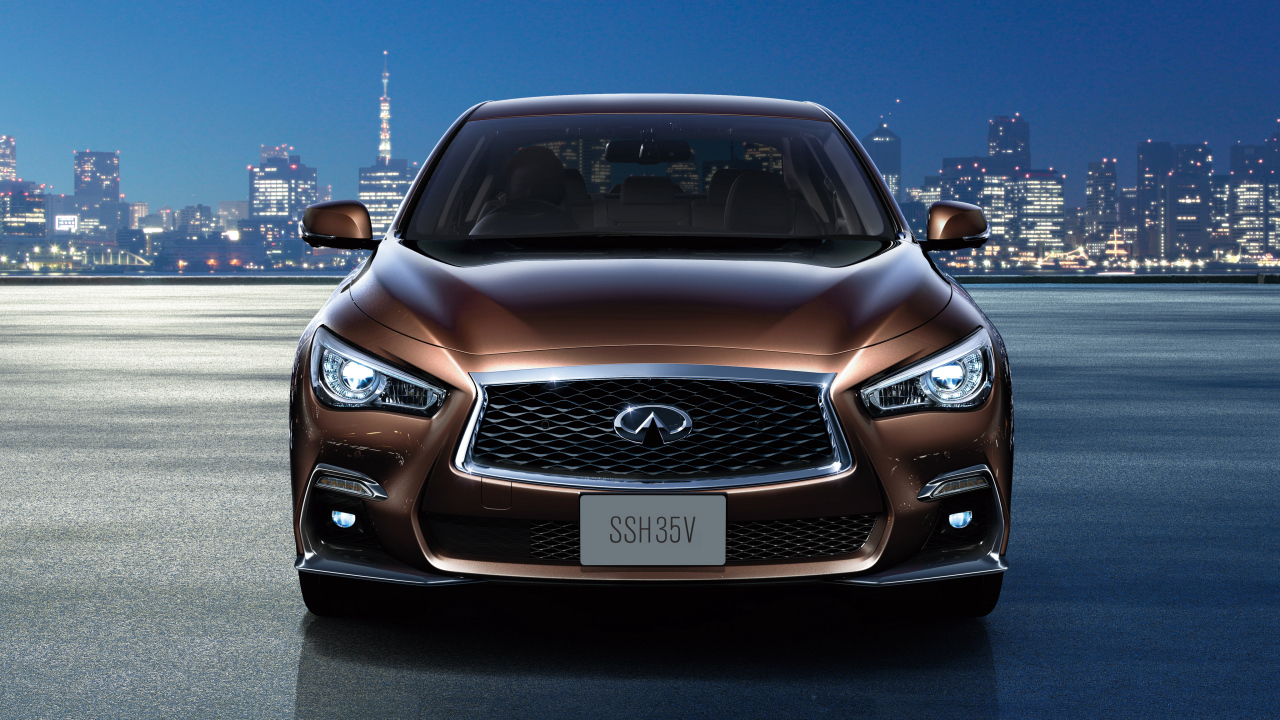 Коричневый автомобиль Nissan Skyline Hybrid, 2018 на фоне ночного города