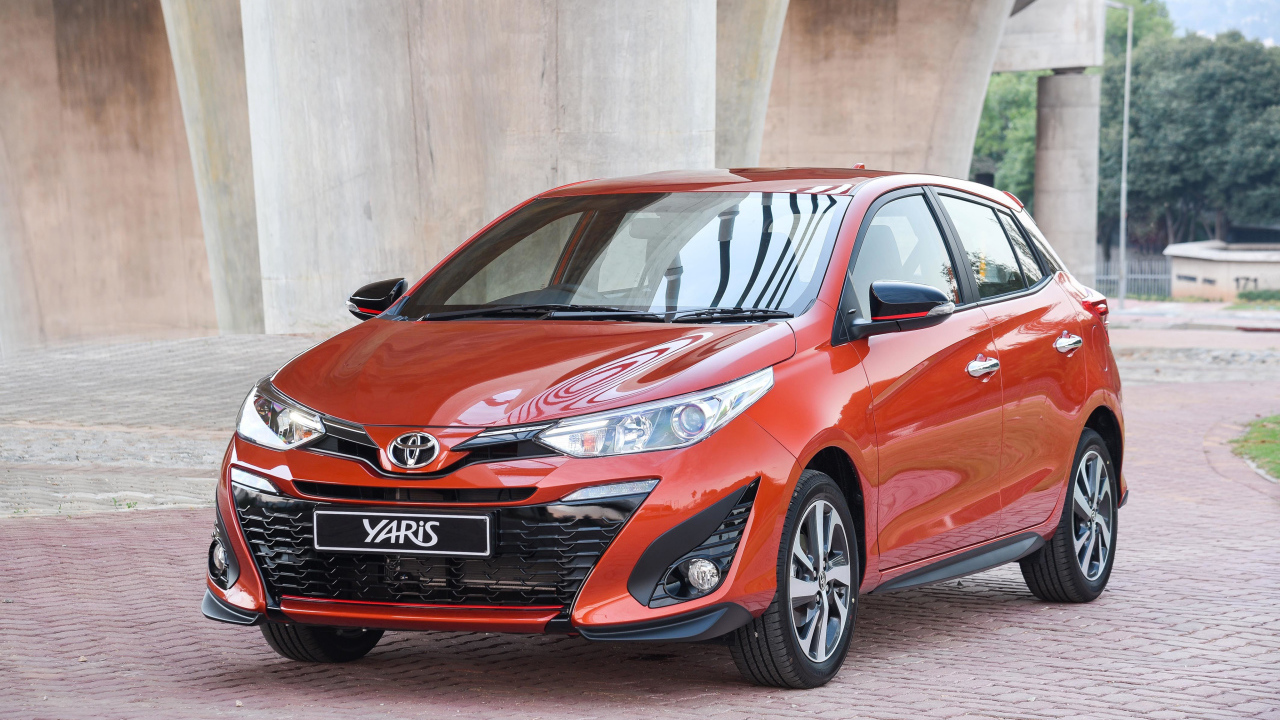 Красный автомобиль Toyota Yaris под мостом 