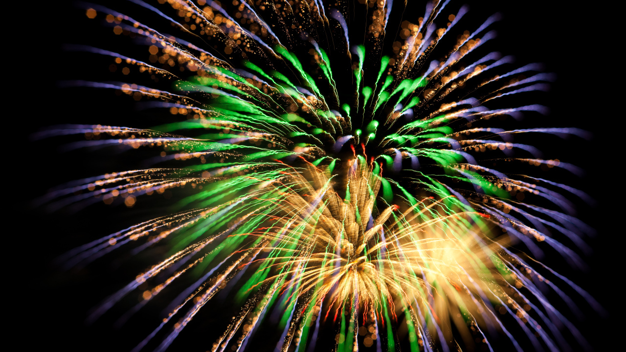 Красивые разноцветные искры праздничного салюта на черном фоне