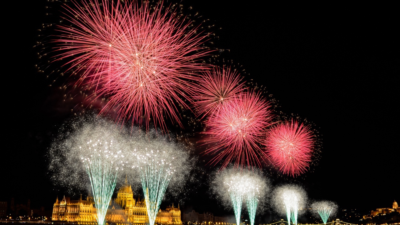 Взрывы яркого салюта над ночным городом 