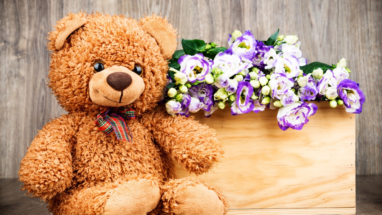 Плюшевый мишка с букетом цветов на деревянном фоне