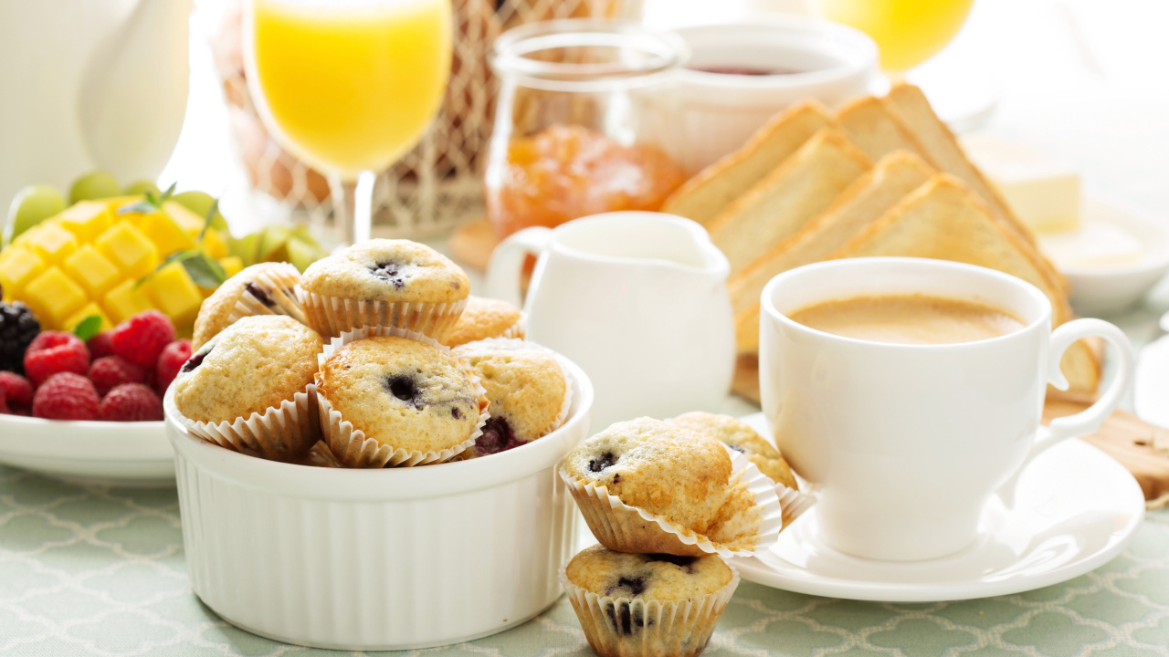 Чашка кофе с кексами на столе 