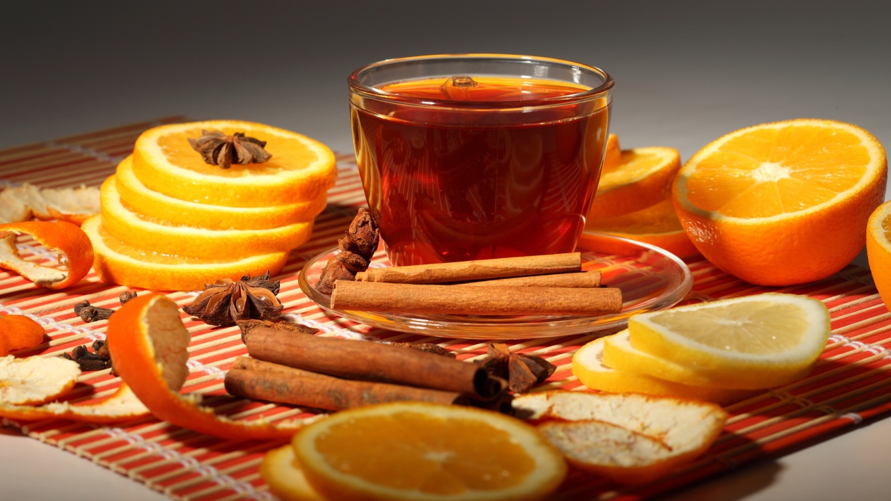 A cup of tea on the table with oranges, cinnamon and star anise