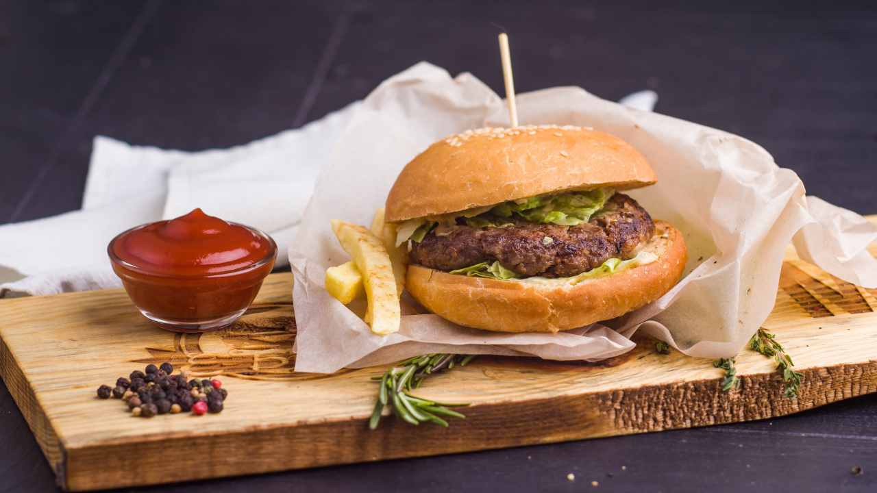 Аппетитный гамбургер с картофелем фри и кетчупом на столе