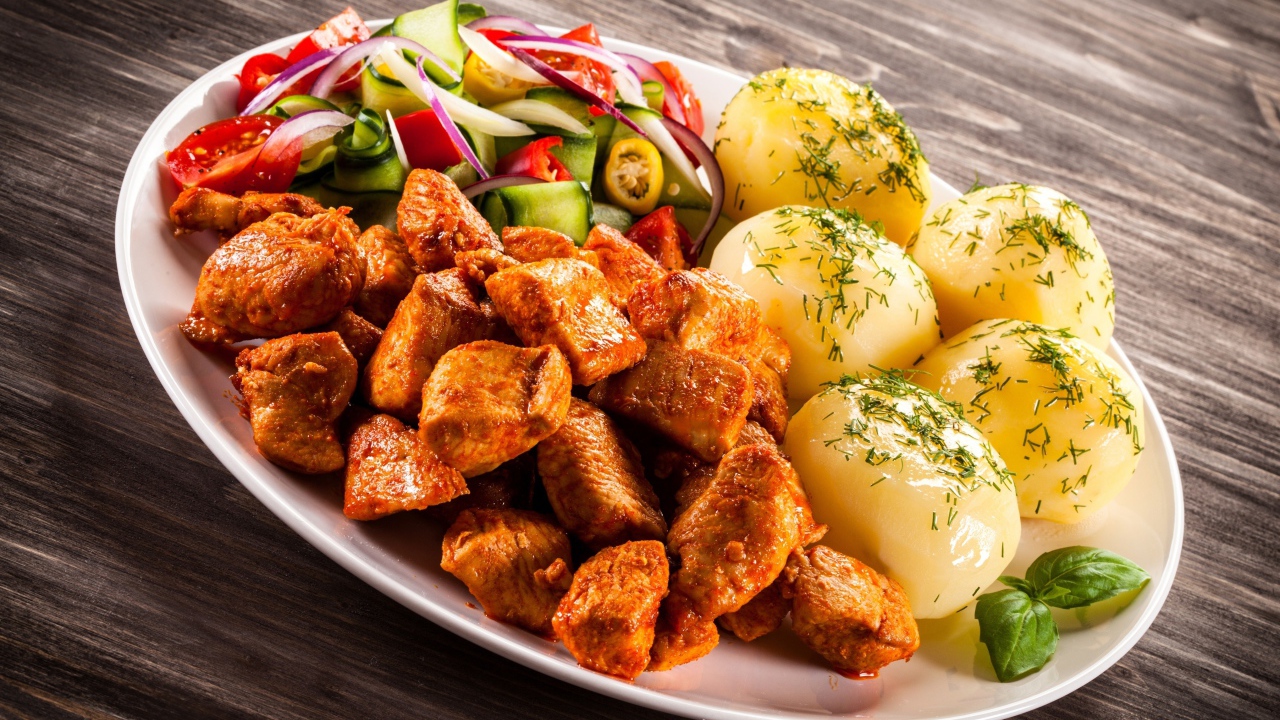 Вареный картофель с мясом и салатом на тарелке