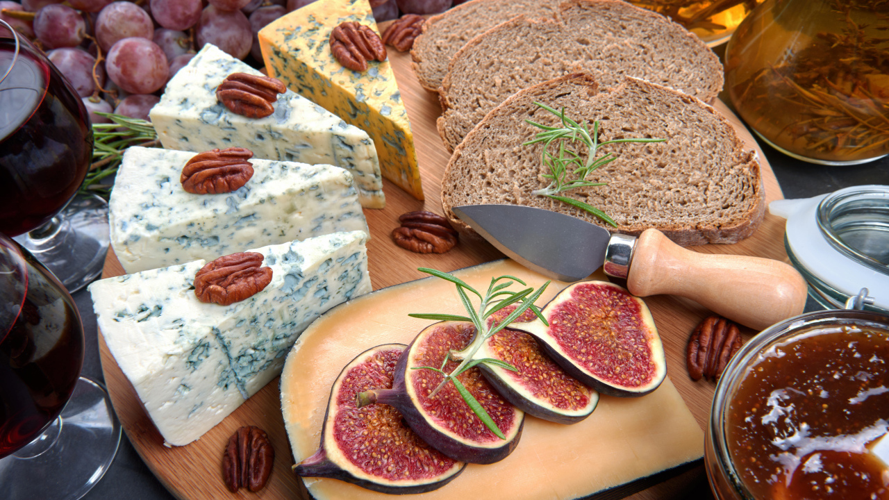Сыр на столе с инжиром и кусками хлеба