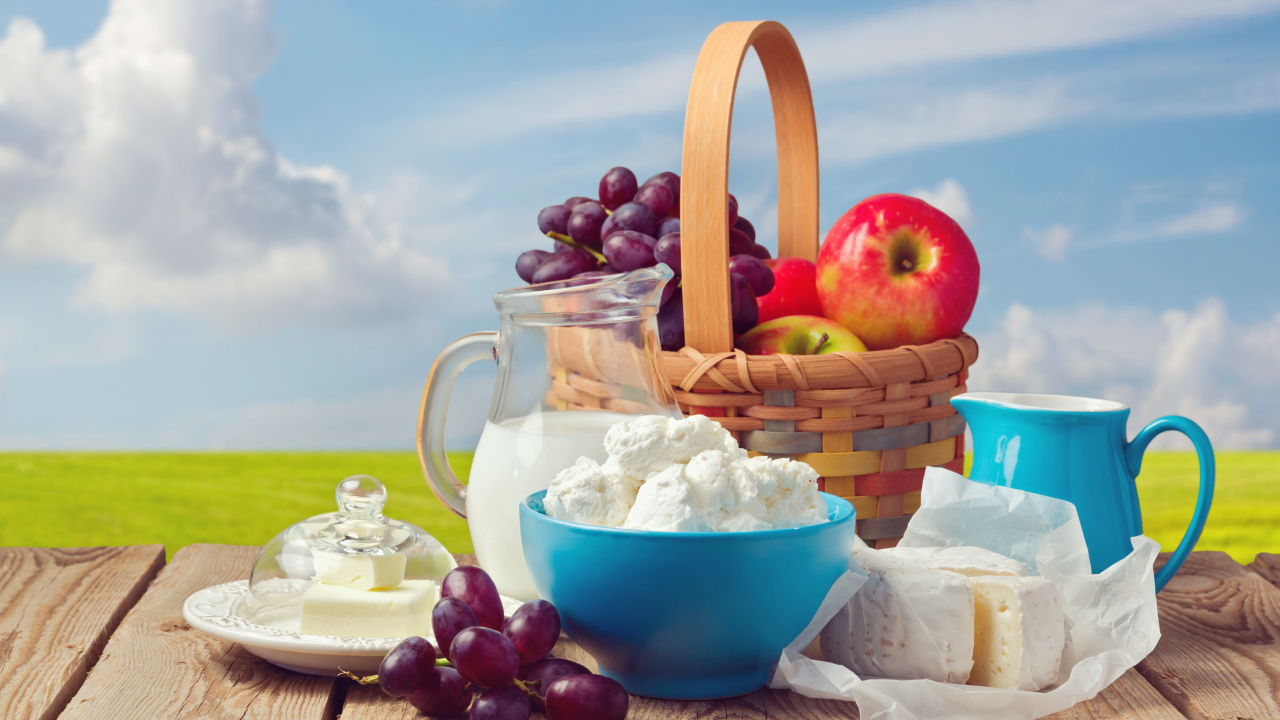 Творог с молоком на столе с виноградом и яблоками 
