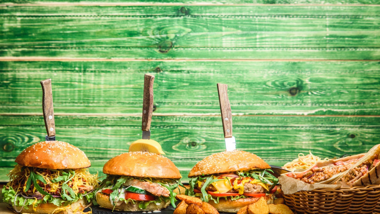 Гамбургеры с ножами на деревянном фоне