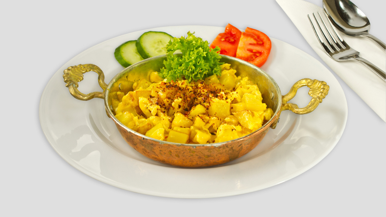 Картофель с овощами на белой тарелке