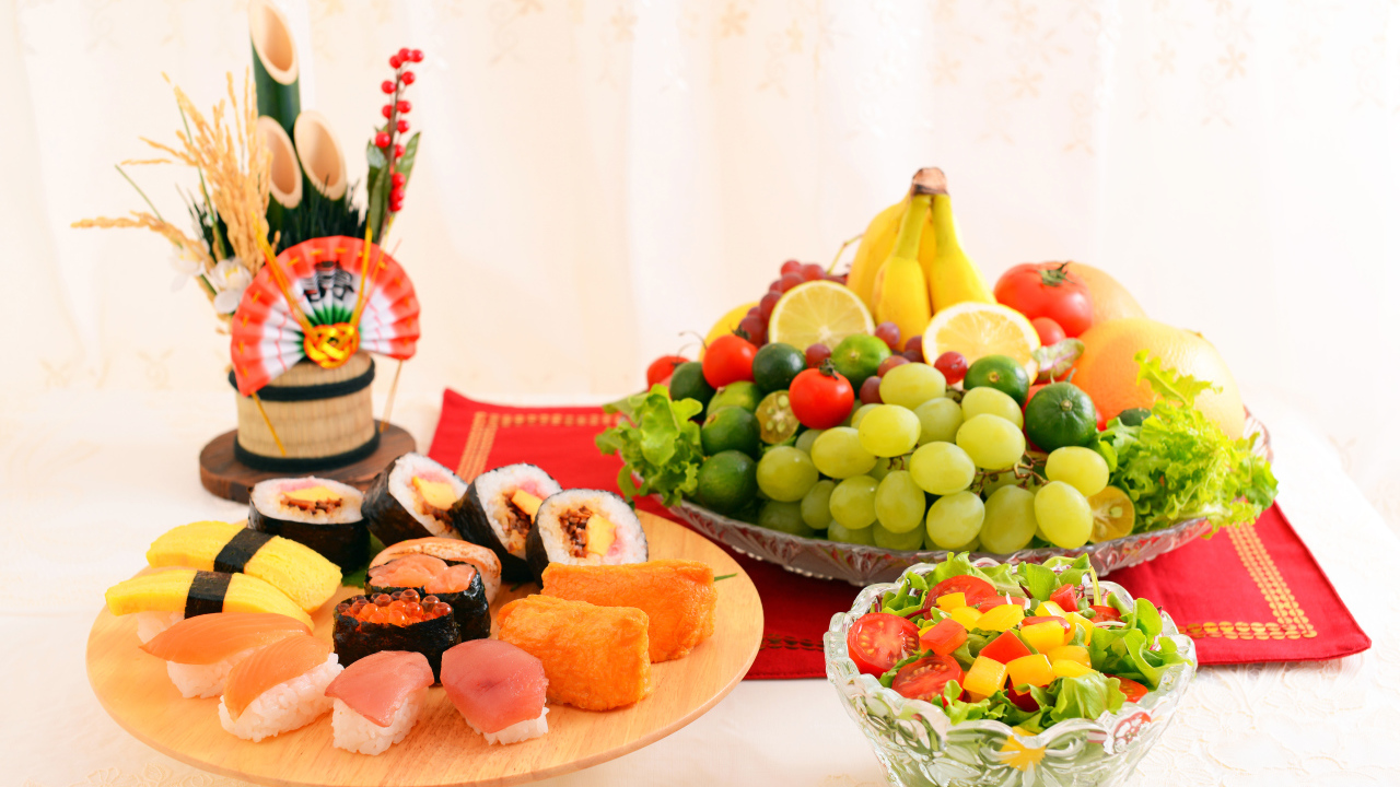 Роллы на столе с овощным салатом и фруктами 