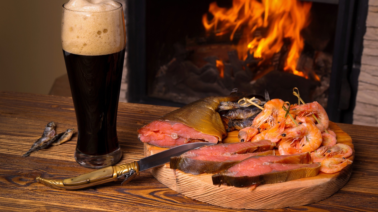 Копченая рыба с креветками у камина с бокалом темного пива