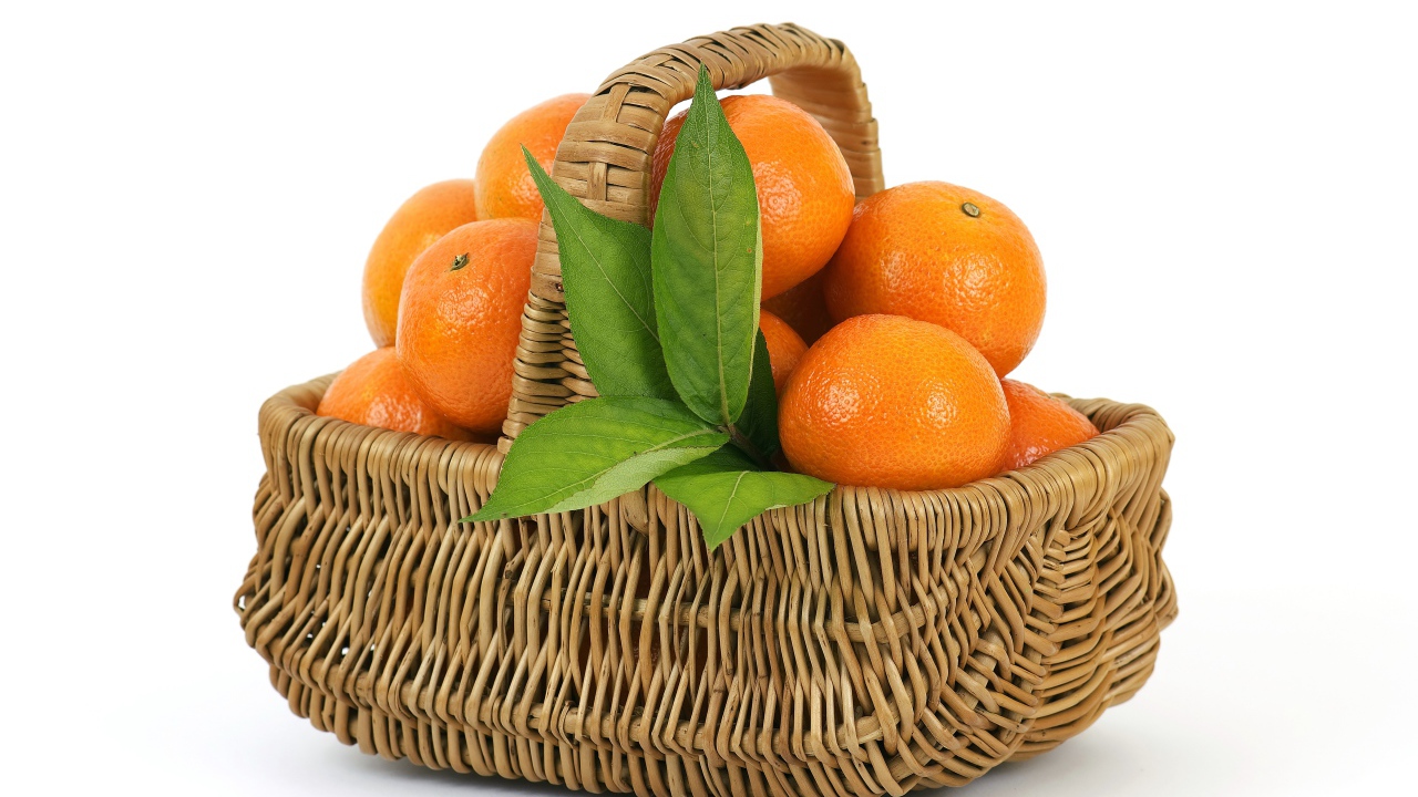 Корзина спелых, сочных оранжевых мандарин на белом фоне