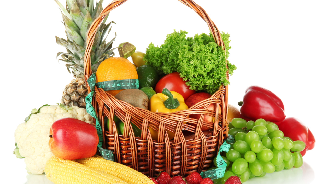 Корзина свежих овощей и фруктов на белом фоне